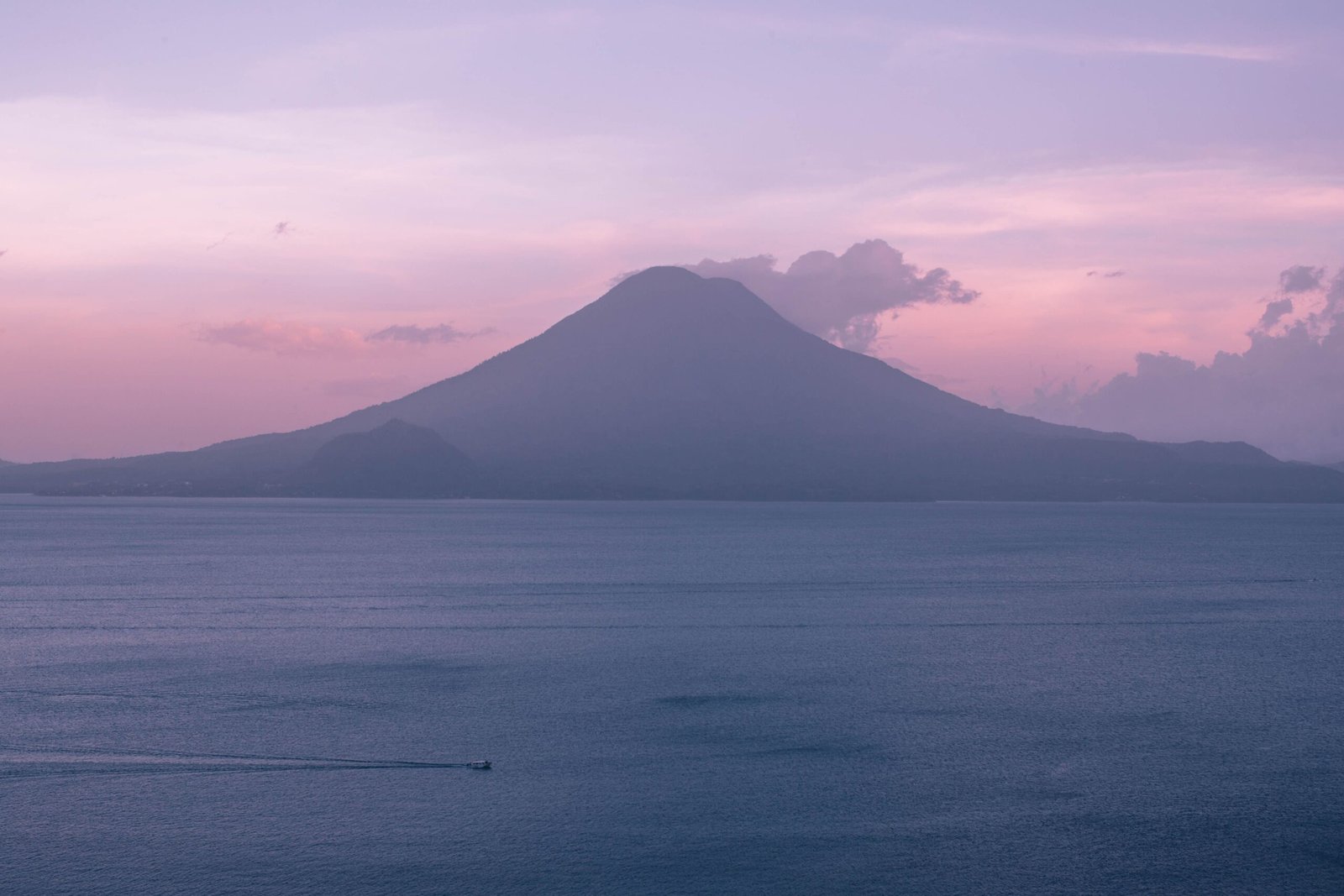 Scenic view of Lake Atitlan with towering volcanoes in the background